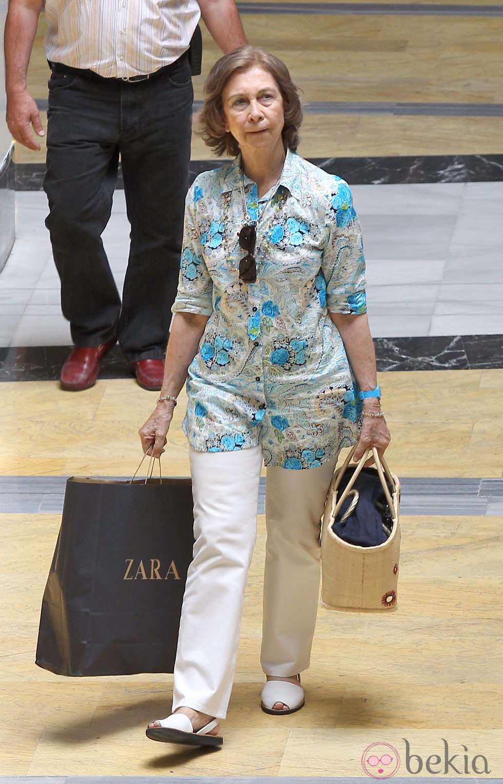 Look de la reina Sofía con blusón de estampado floral y pantalón blanco en verano de 2010