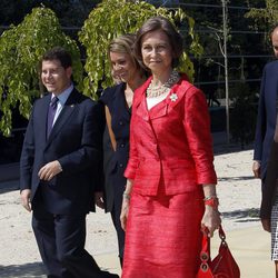 Look de la reina Sofía con vestido lady de color rojo, con textura en relieve y broche floral