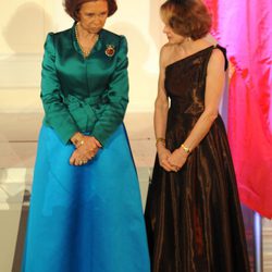 Look de la reina Sofía con vestido de gala largo de tendencia color block combinando falda en azul cian y chaqueta en verde de textura satinada