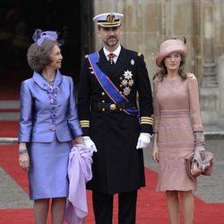Look de la reina Sofía con vestido de gala corto de textura satinada en color malva con detalles florales en los botones