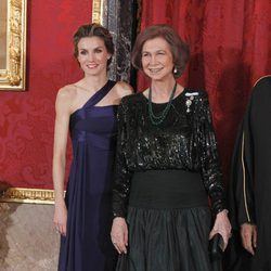 Look de la reina Sofía con vestido de gala largo compuesto por falda en verde dark y fajín y parte superior negra glitter