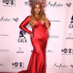 Look elegante premamá de Beyoncé con vestido largo rojo y tocado de flores