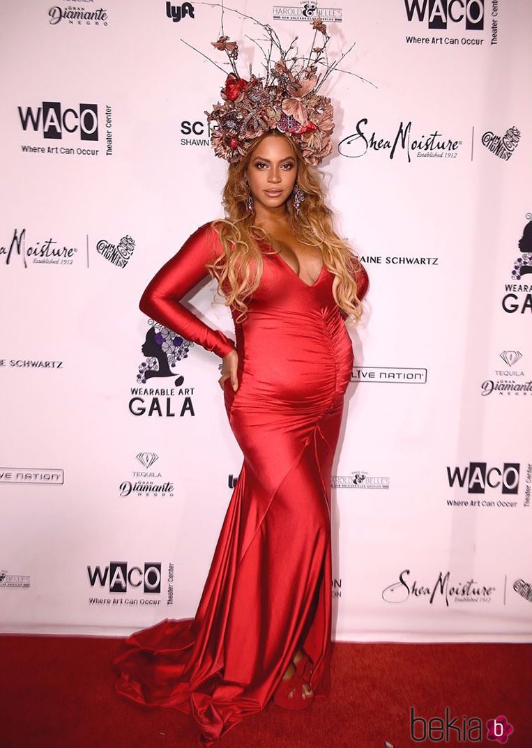 Look elegante premamá de Beyoncé con vestido largo rojo y tocado de flores