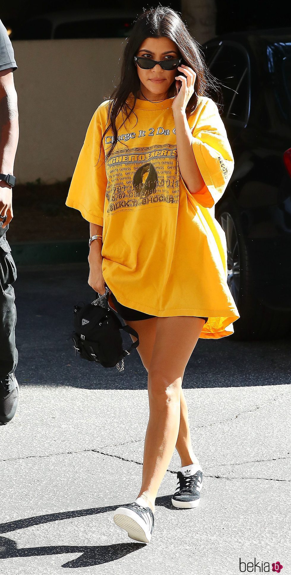 Kourtney Kardashian con camiseta amarilla oversize y shorts negros