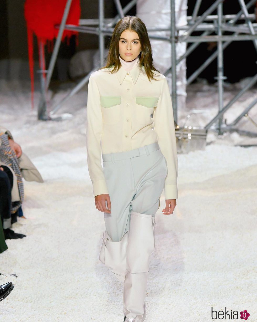Kaia Gerber desfilando con un outfit en tonos blancos y unas botas blancas 2018