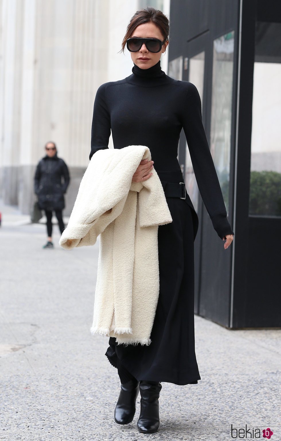 Victoria Beckham con un look negro y abrigo blanco por las calles de Nueva York 2018