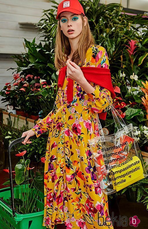 Vestido mostaza con estampado de flores con una gorra de la nueva colección de primavera 2018 de Stradivarius