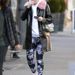 Dakota Fanning con un abrigo negro de charol y pelo rosa por las calles de Nueva York 2018