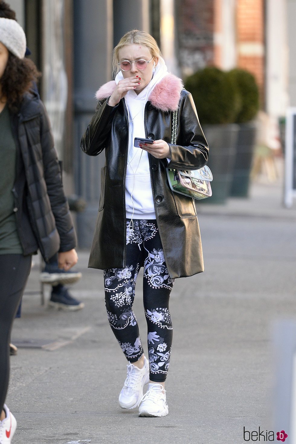 Dakota Fanning con un abrigo negro de charol y pelo rosa por las calles de Nueva York 2018