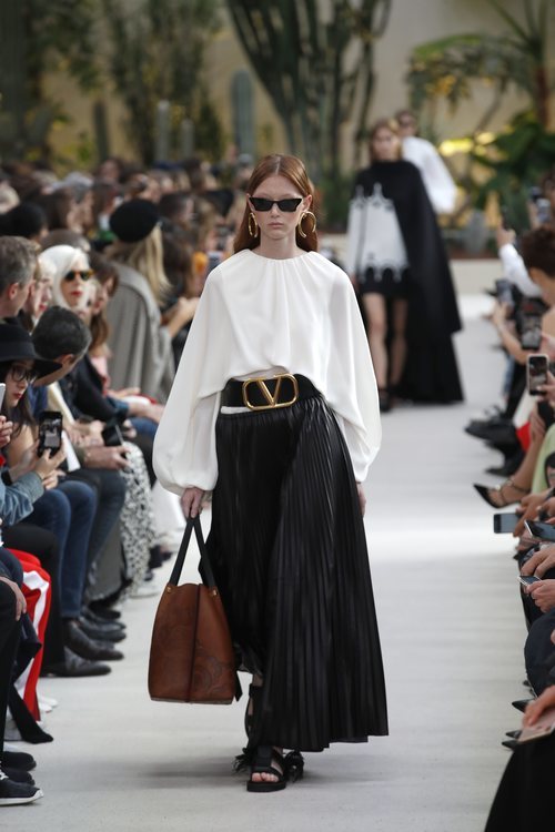 Modelo con una blusa blanca y una falda negra de la colección primavera/verano 2019 de Valentino presentada en Paris Fashion Week