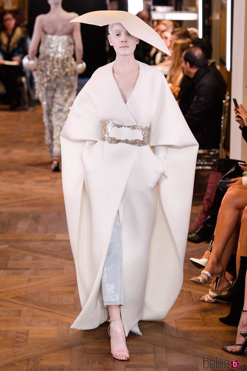Abrigo largo blanco con cinturón y mangas capa de la colección Alta Costura Primavera 2019 de Balmain