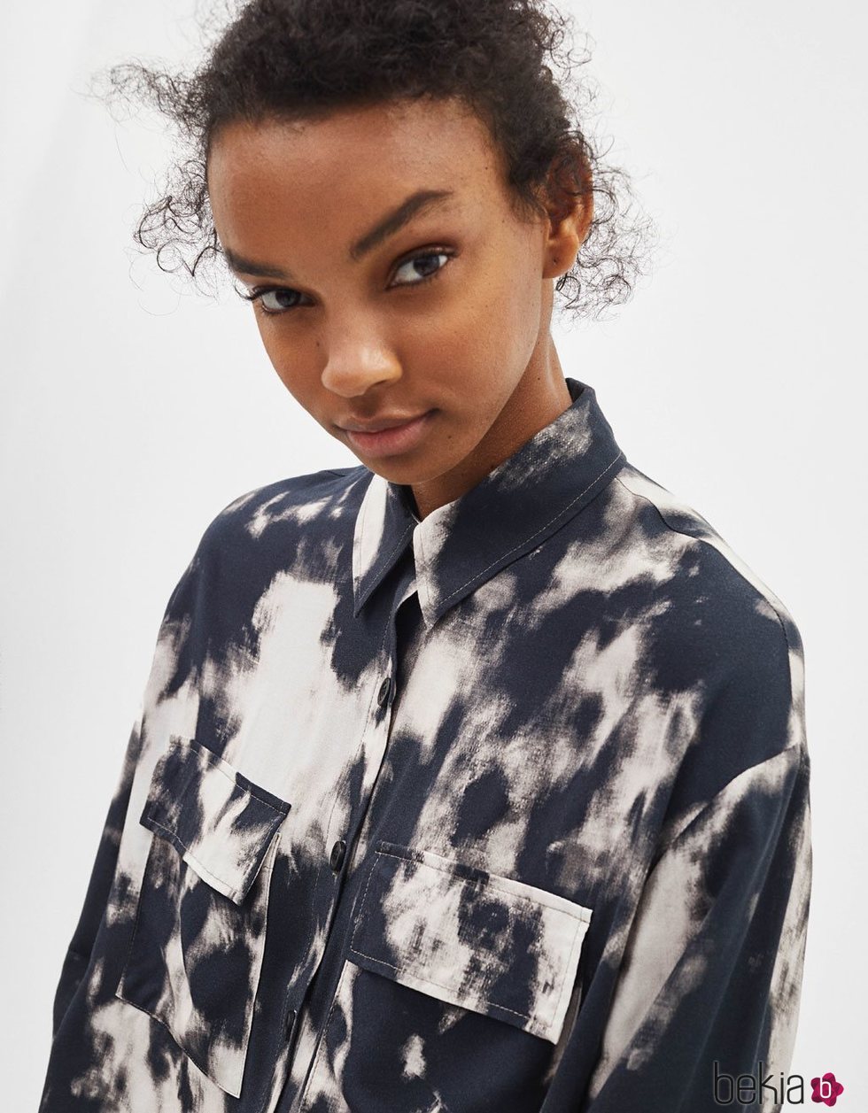 Modelo luciendo una camisa estampada en tonos oscuros de la colección de primavera 2019 de Bershka