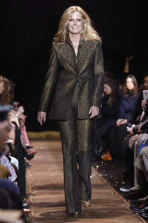 Patti Hansen con un traje de chaqueta dorado de Michael Kors en la New York Fashion Week 2019