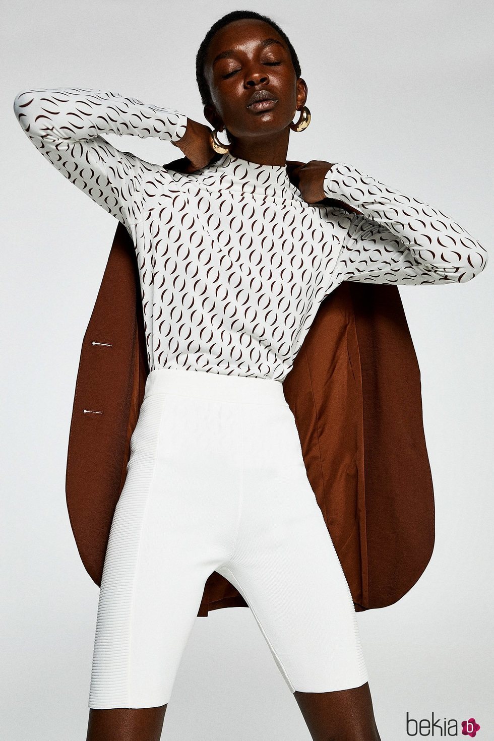 Modelo con un conjunto marrón y blanco de la colección primavera/verano 2019 de Sfera