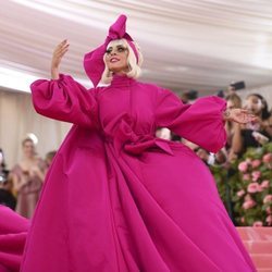 Lady Gaga con un vestido capa rosa en la alfombra roja de la Gala MET 2019