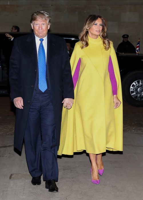 Melania Trump con un abrigo capa en amarillo con complementos rosa fucsia en la cumbre de líderes de la OTAN