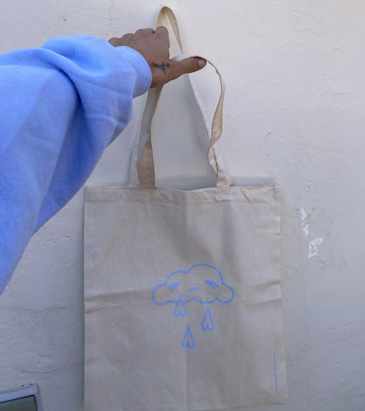 Natalia Lacunza mostrando la tote bag de su línea de merchandising