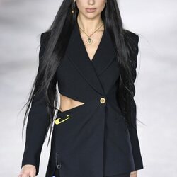 Dua Lipa con un traje de chaqueta y falda en el desfile primavera/verano 2022 de Versace