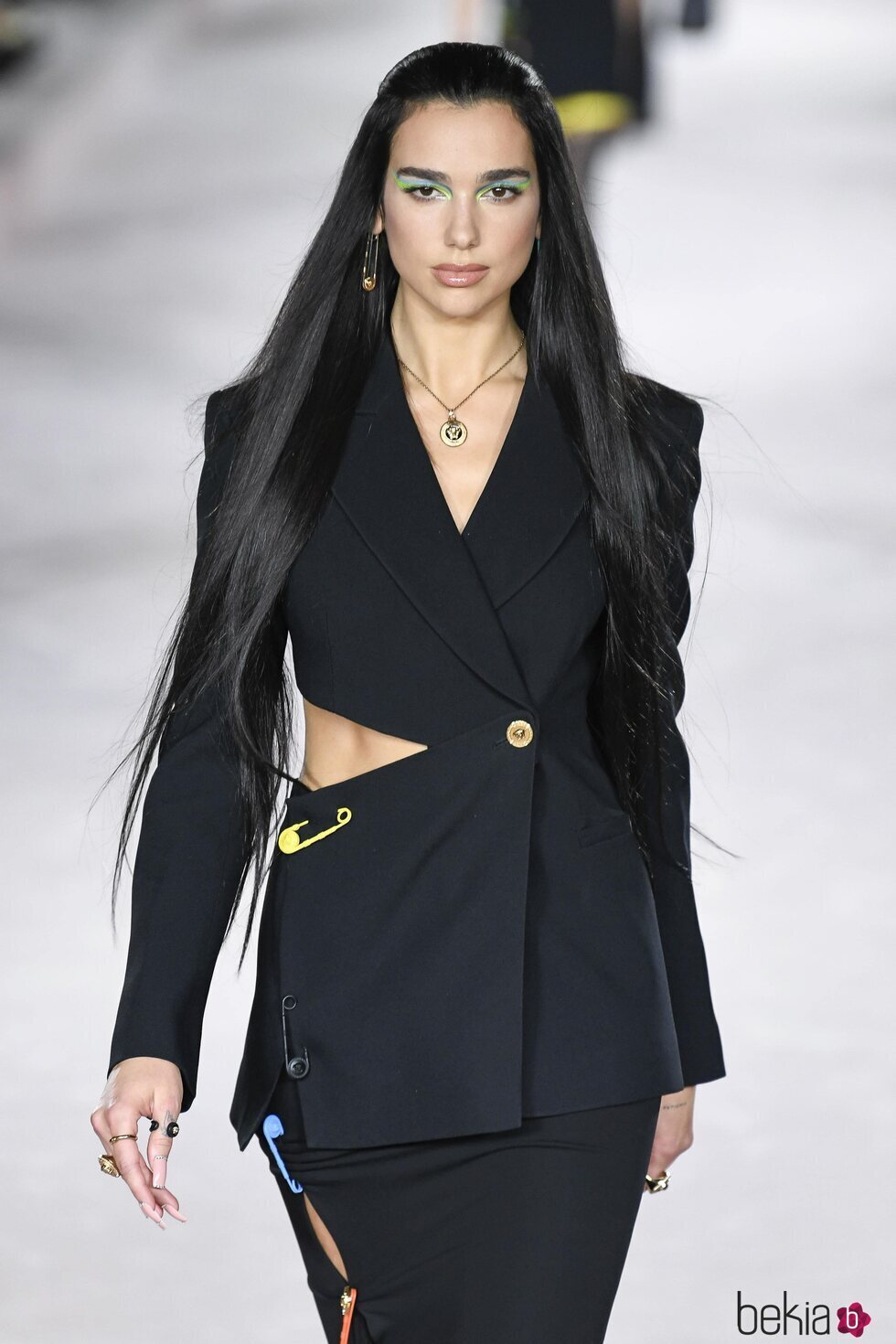 Dua Lipa con un traje de chaqueta y falda en el desfile primavera/verano 2022 de Versace