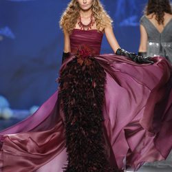Desfile de Francis Montesinos en la Fashion Week Madrid: vestido largo burdeos con plumas del mismo tono