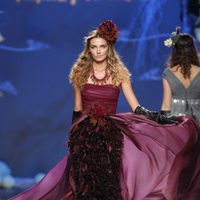 Desfile de Francis Montesinos en la Fashion Week Madrid: vestido largo burdeos con plumas del mismo tono