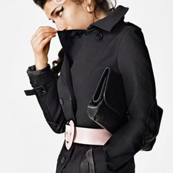 Amy Winehouse con un abrigo negro y lazo rosa para Fred Perry