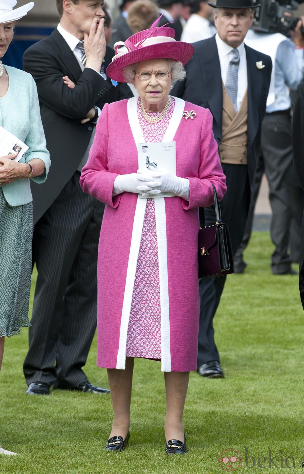 La Reina Isabel II con un llamativo modelo rosa fucsia y blanco