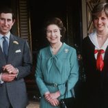 La Reina Isabel II de Inglaterra con un vestido azul turquesa con lazada en el cuello