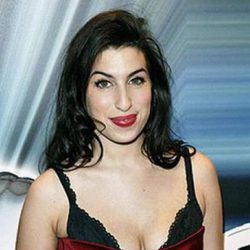Amy Winehouse deja asomar su sujetador con un ajustado vestido rojo