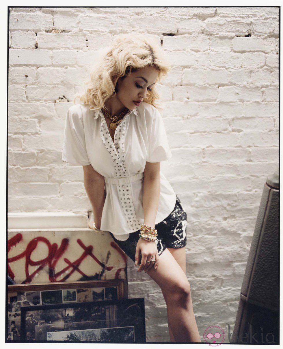 Rita Ora posa con camisa blanca de motivos dorados y shorts vaqueros para la revista Asos Magazine