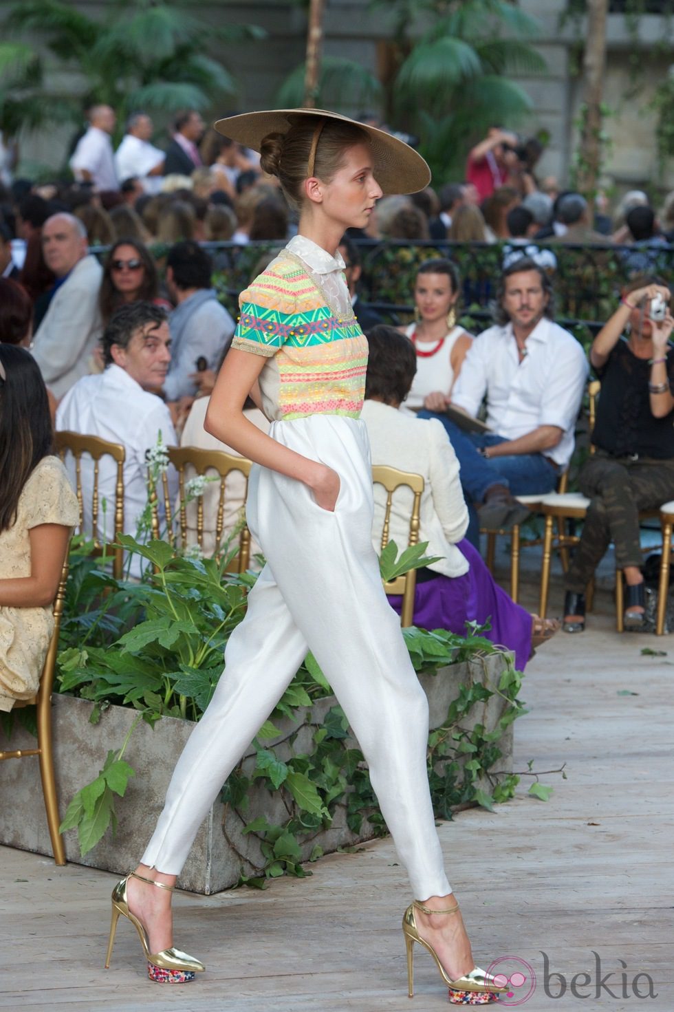 Traje pantalón, camisa estamapada con pantalón blanco combinado con un tocado y zapatos de plataforma dorados  de la colección primavera-verano 2013 de la