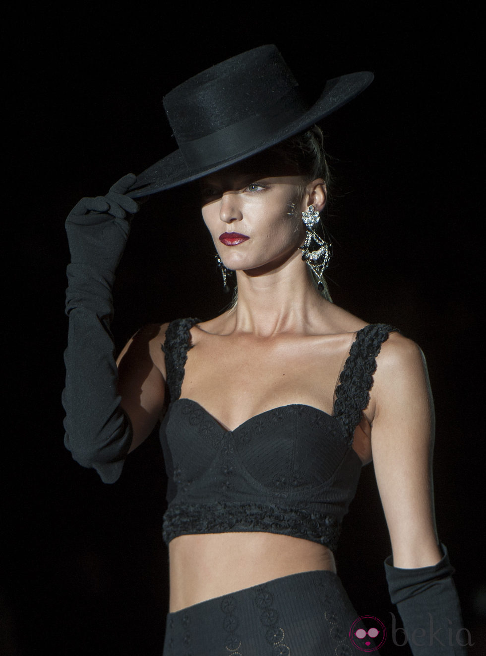 Pantalón y top negro con sombrero de copa, guantes y abanico en la colección primavera-verano 2013 de Roberto Verino