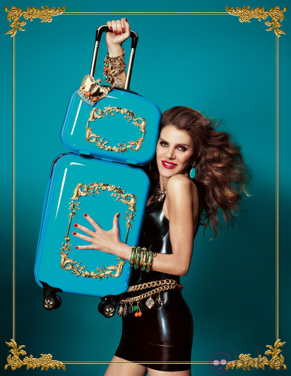 Anna Dello Russo posando con dos maletas de su colección para H&M