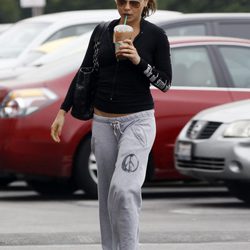 Mila Kunis en chandal y con chanclas con un café en la mano