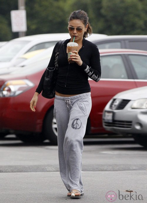 Mila Kunis en chandal y con chanclas con un café en la mano