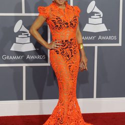 Fergie con un vestido largo de encaje naranja que transparenta su ropa interior
