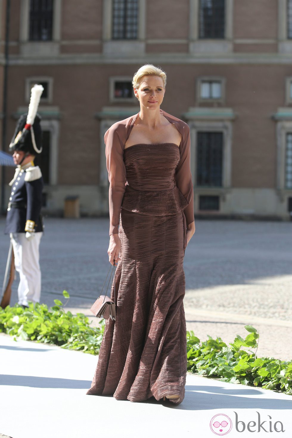 La Princesa Charlene de Mónaco con  un vestido marrón peplum en la boda de Magdalena de Suecia y Chris O'Neill