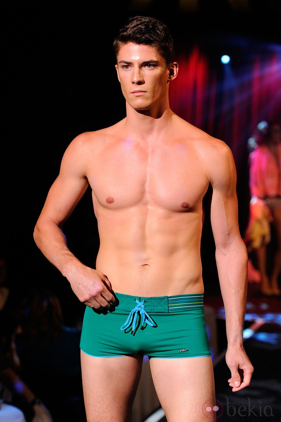 Modelo con torso desnudo y bañador verde de 2(X)ist para verano de 2012