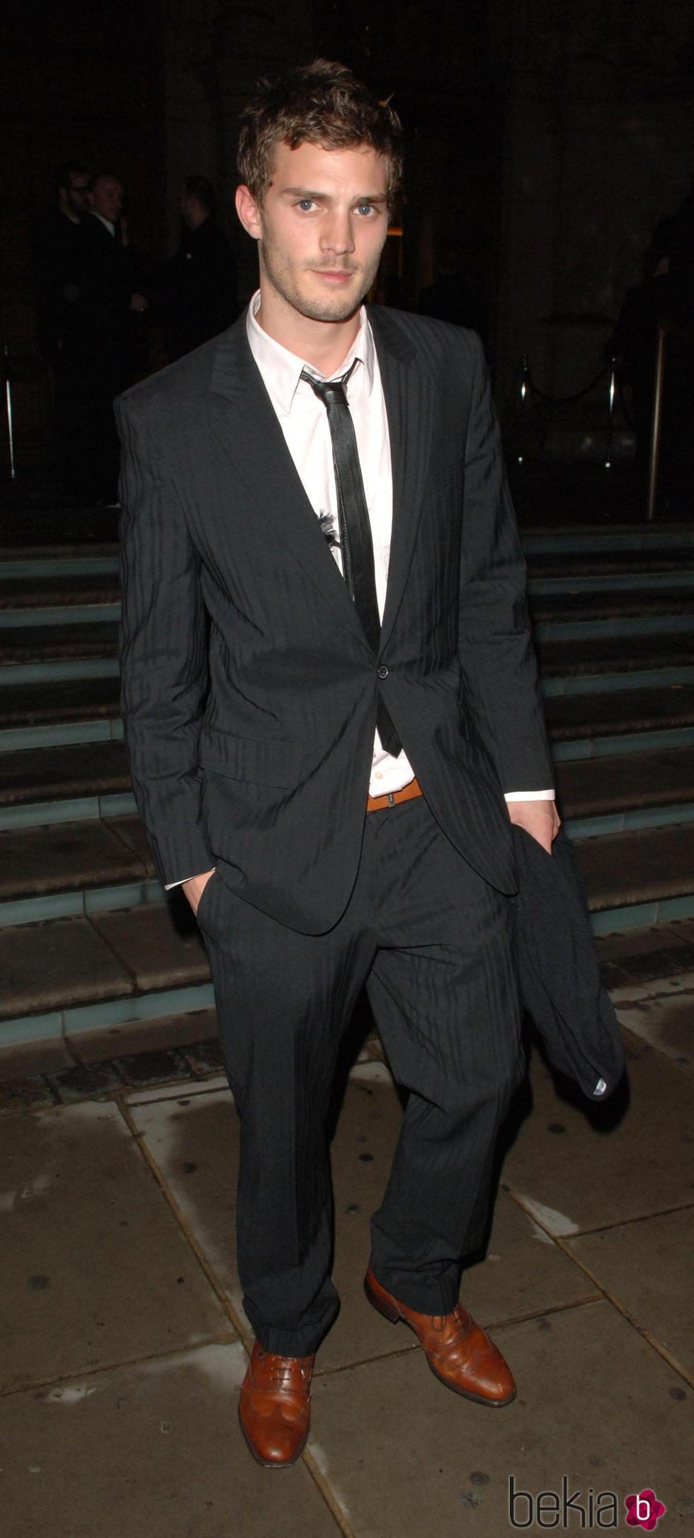 Jamie Dornan con traje negro, camisa blanca y corbata estrecha