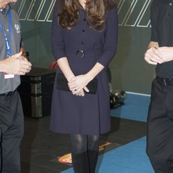 Kate Middleton con un vestido azul oscuro y botas altas negras