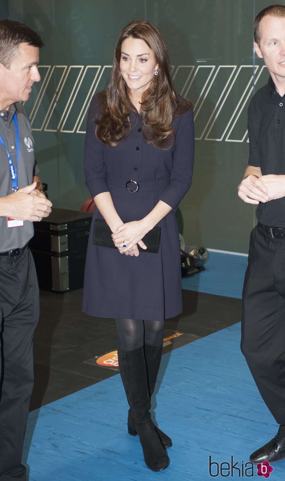 Kate Middleton con un vestido azul oscuro y botas altas negras