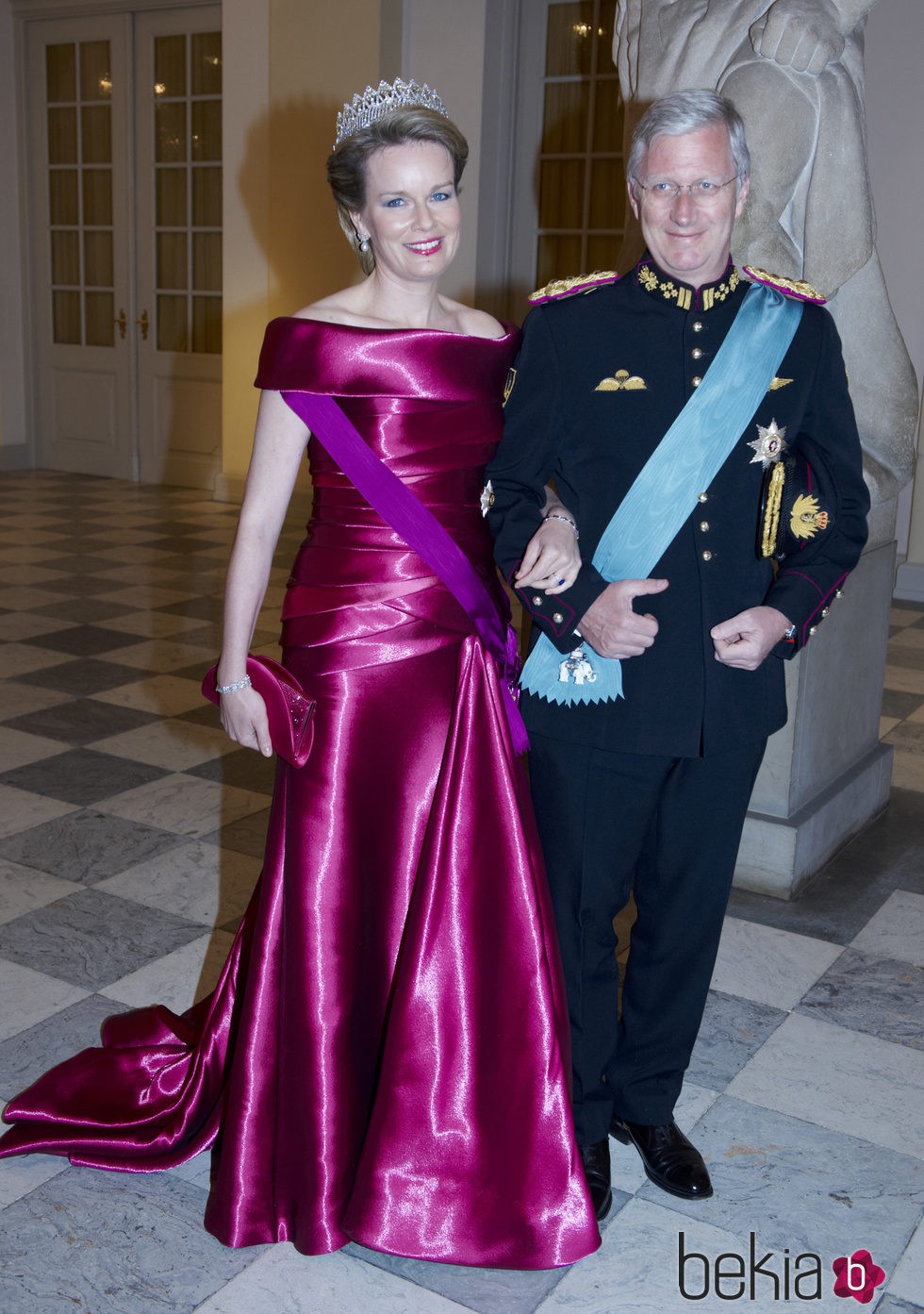 Reina Matilde de Bélgica con un vestido en color fucsia