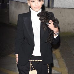 Rita Ora con traje negro, camiseta blanca básica y su perro a modo de complemento