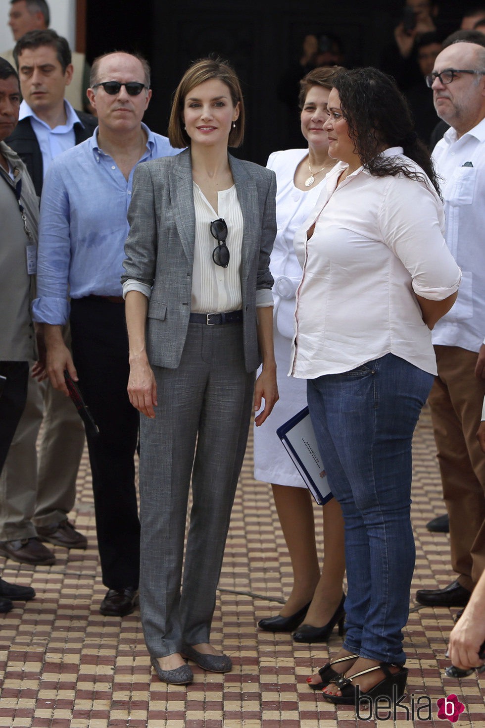 La Reina Letizia con un traje gris de Hugo Boss y una camisa de algodón blanca en El Salvador