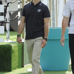 Carlos Felipe de Suecia con un polo azul oscuro, pantalones chinos beige y gafas de sol deportivas