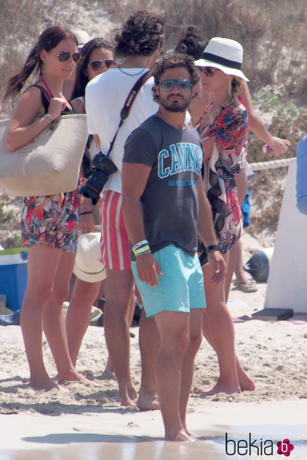 Carlos Felipe de Suecia con camiseta de algodón, bañador azul celeste y gafas de sol sport