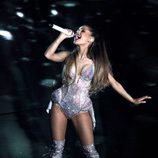 Ariana Grande con un body plateado con incrustaciones brillantes y botas altas a juego