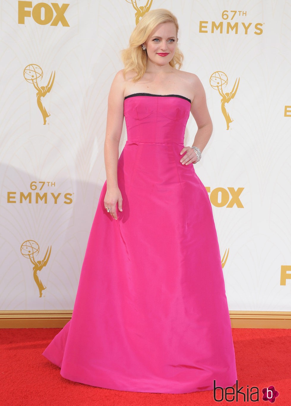 Elisabeth Moss con vestido fucsia en la alfombra roja de los premios Emmy 2015