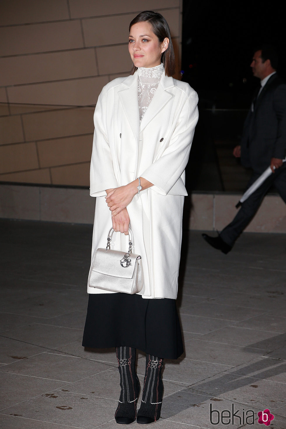 Marion Cotillard con gabardina blanca y falda negra en la inauguración de la fundación Louis Vouitton en 2014