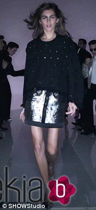 Modelo desfilando con un jersey negro y falda plateada en la nueva campaña del diseñador Tom Ford